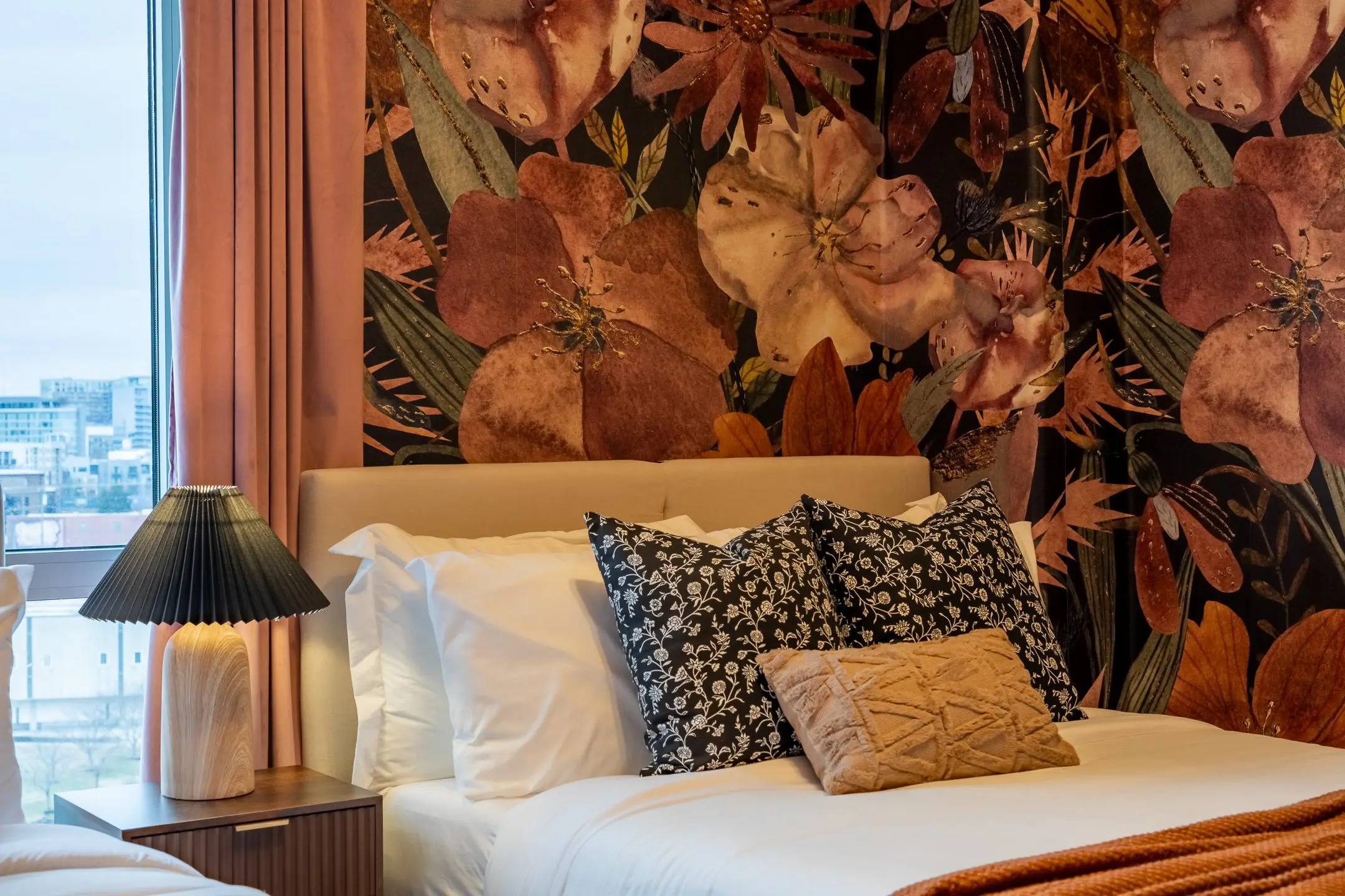 The Velvet Hour, a Nashville luxury vacation rental bedroom with an oversized plum and copper floral mural and crisp white hotel linens, designed by Toile & Oak